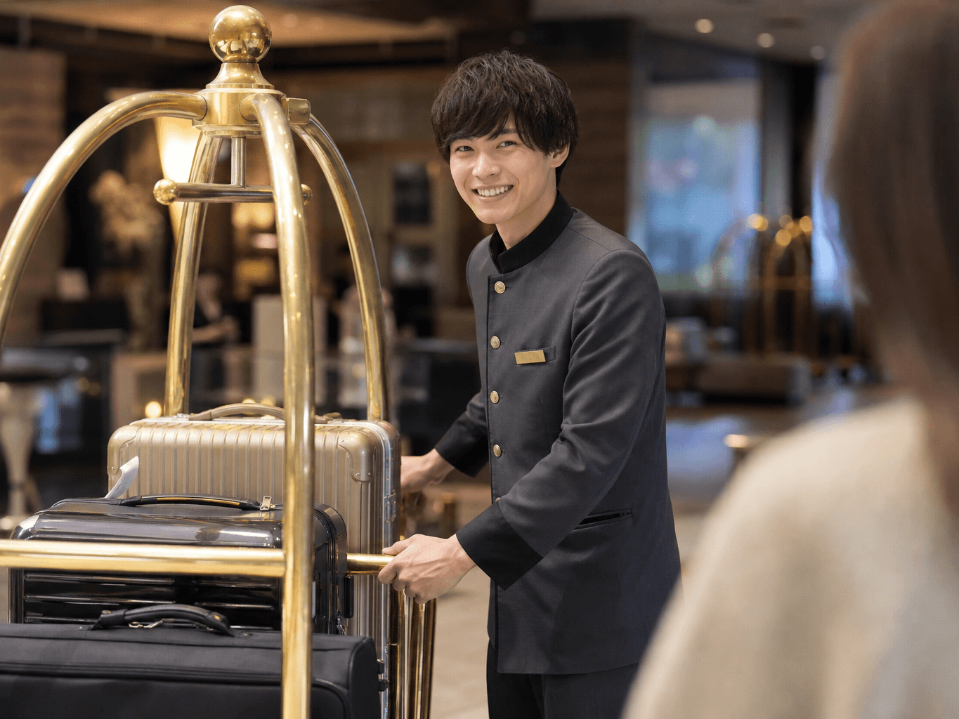 荷物を運ぶホテルのベルスタッフ - Hotel Bellhop Carrying Guest Luggage