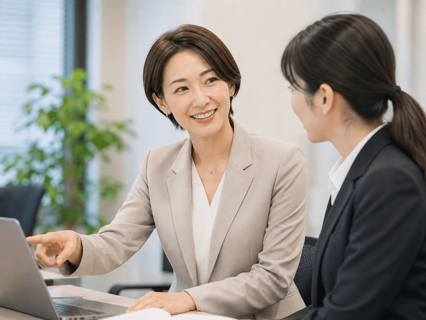 デスクで新人にアドバイスする先輩社員 - Senior Employee Advising a Junior Colleague at an Office Desk