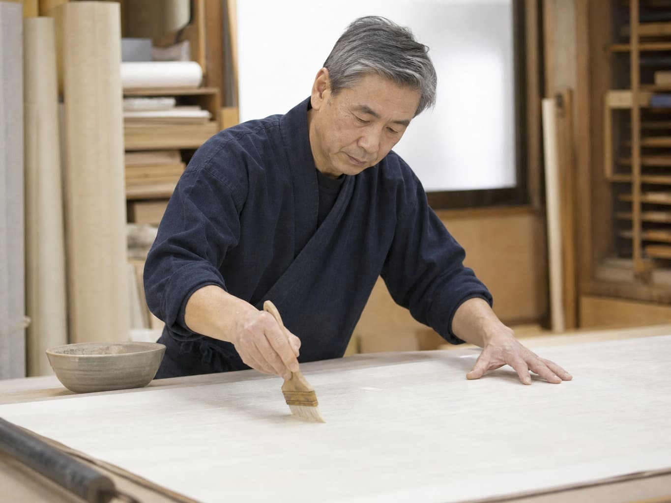 和紙の裏打ちをする表具師 - Scroll mounter applying paste to washi paper