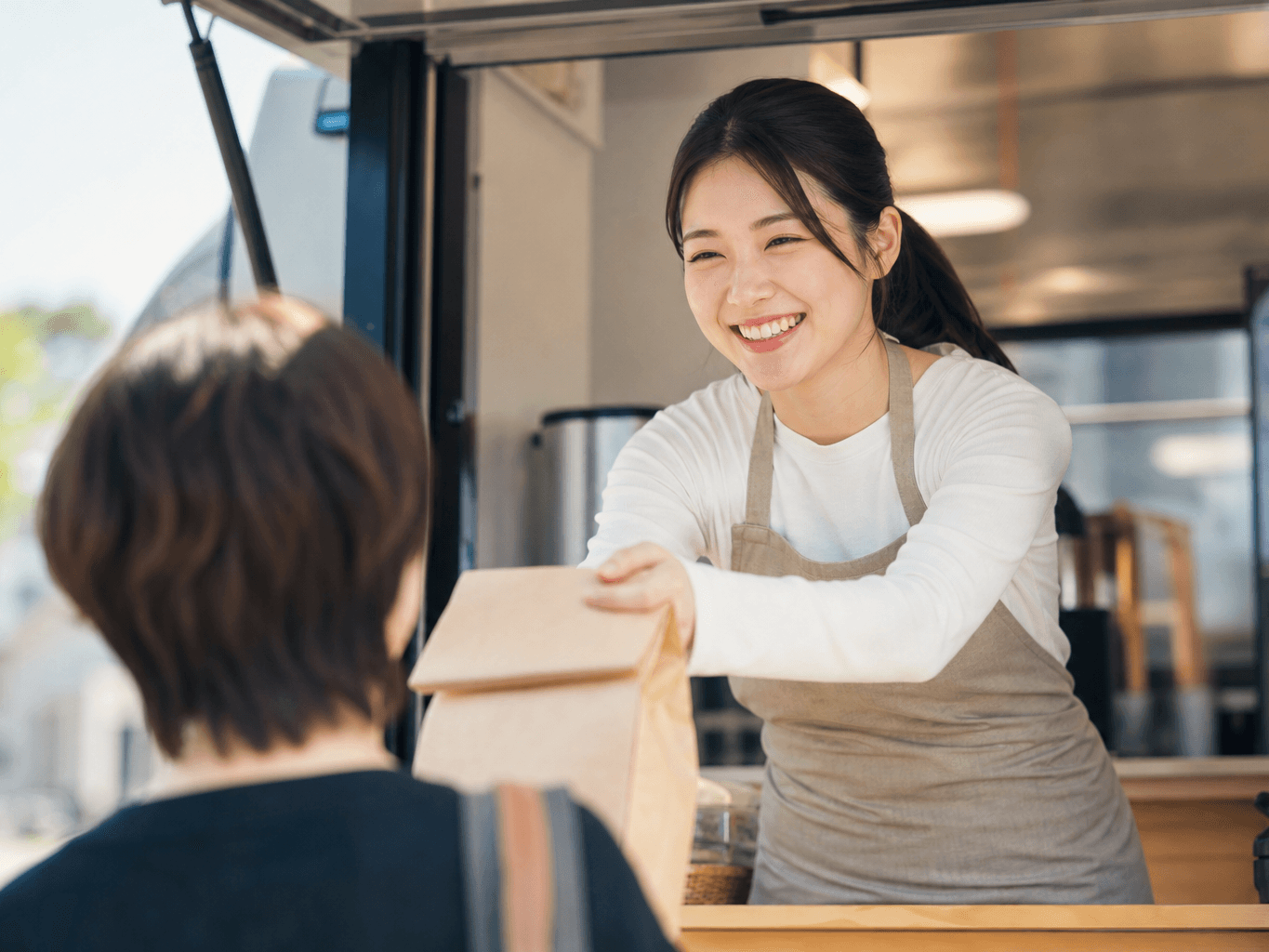 接客をするキッチンカーの店員 - Food Truck Staff Serving a Customer