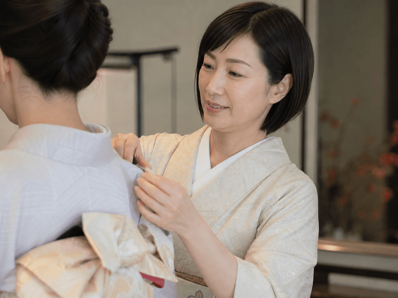 着物の着付けをする着付け師 - Kimono Dresser Tying an Obi Sash