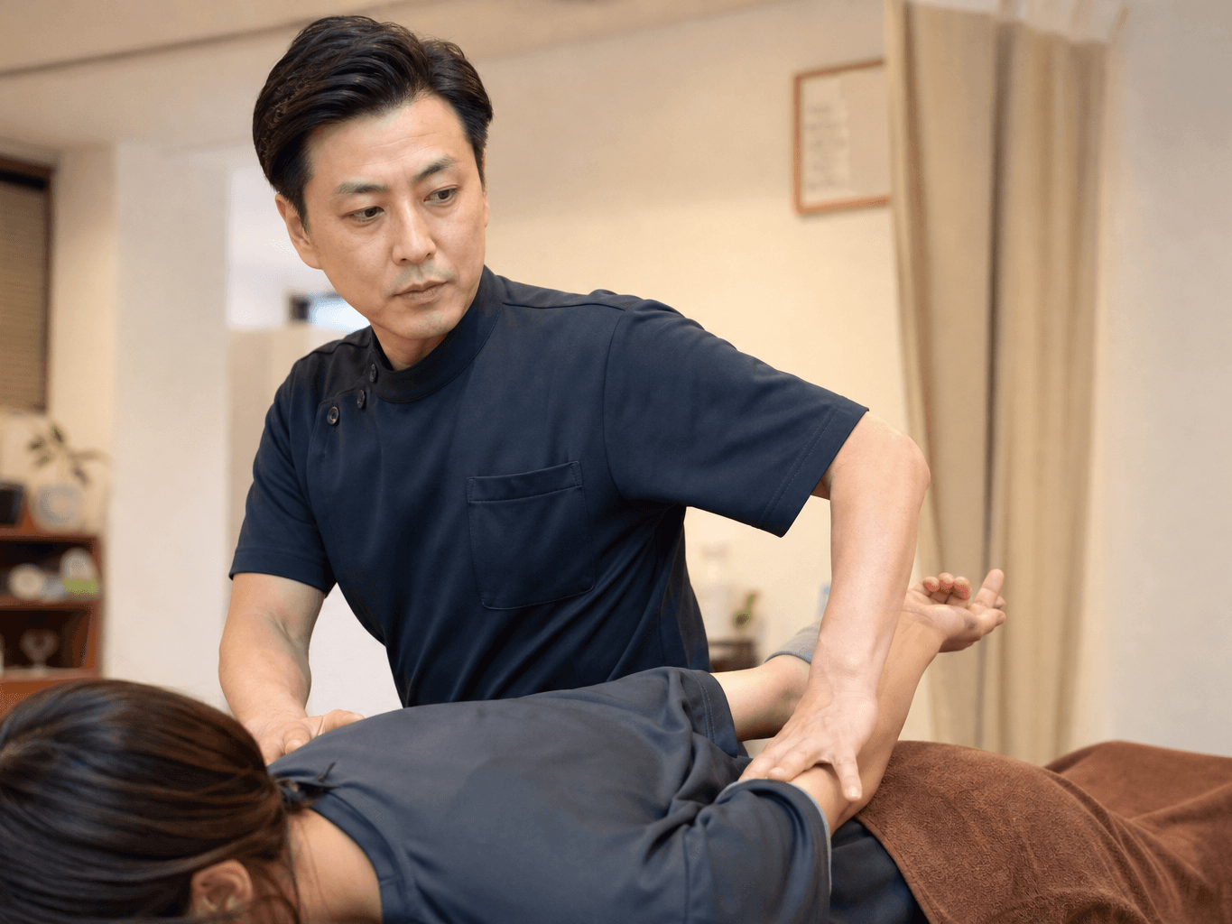 施術をする整体師 - Chiropractor Treating a Client's Back