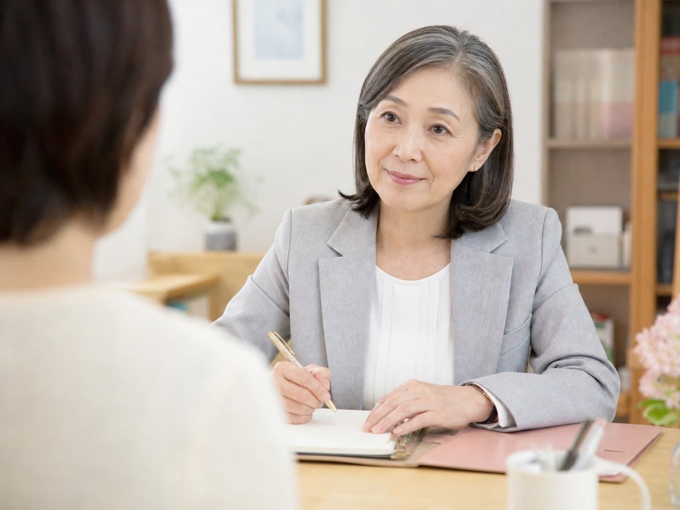 相談者の話を聞く社会福祉士 - Social worker listening to a client in a consultation room