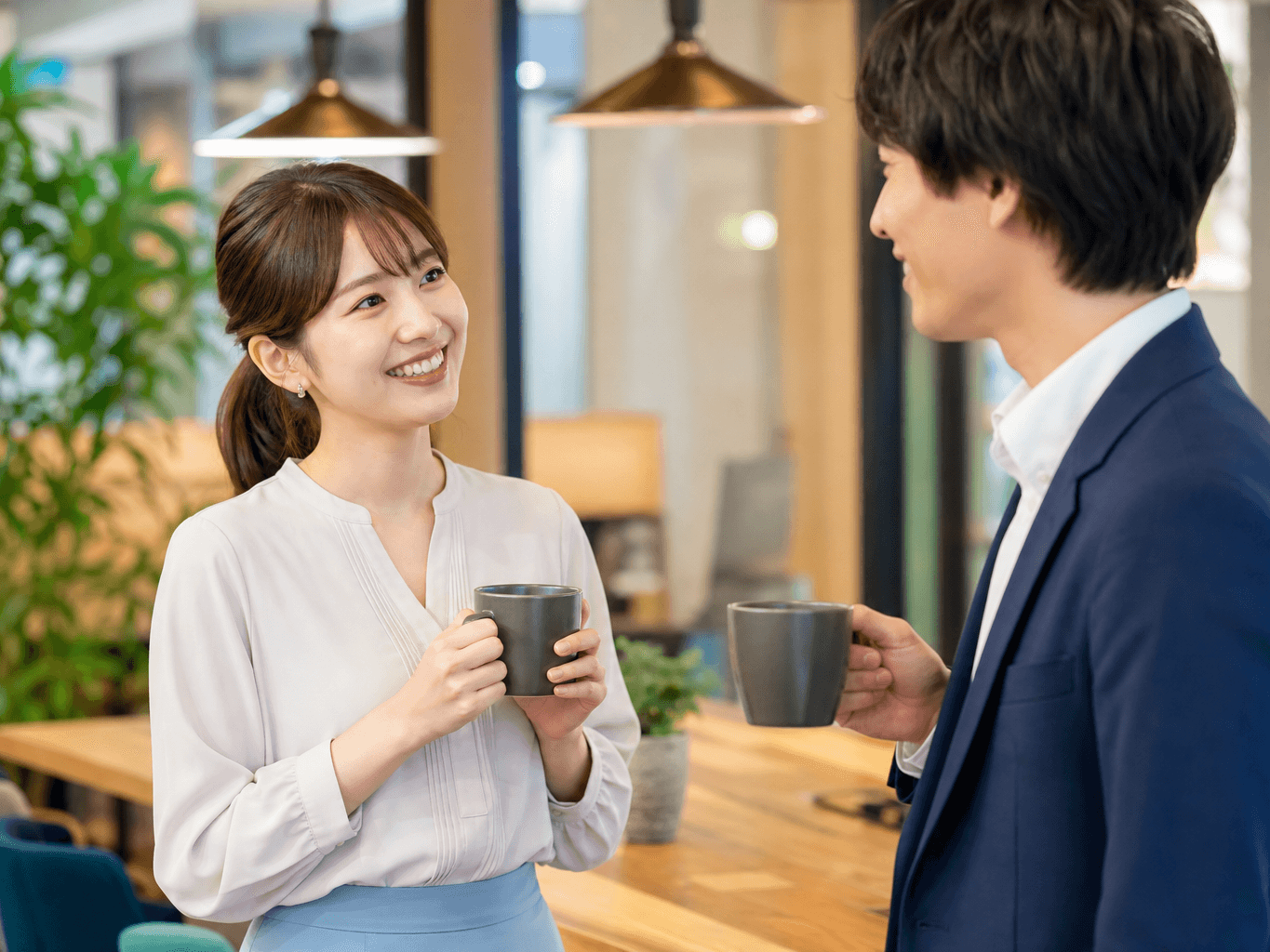 オフィスラウンジで談笑する男女の同僚 - Colleagues chatting over coffee in office break room
