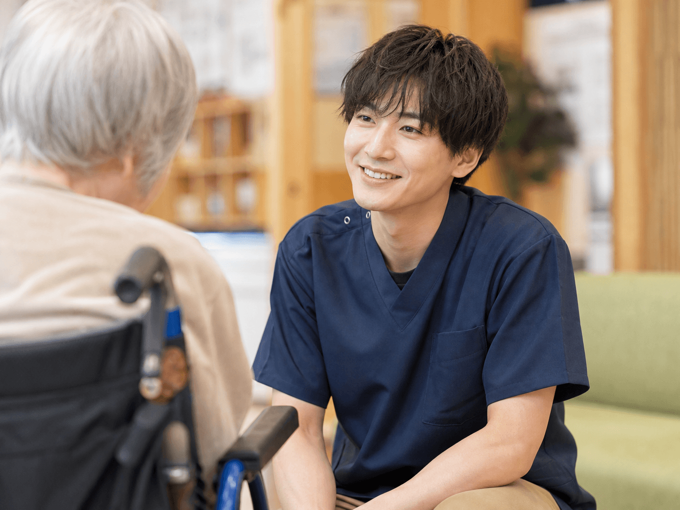 利用者の話に耳を傾ける介護士 - Caregiver Listening to a Resident at a Care Facility
