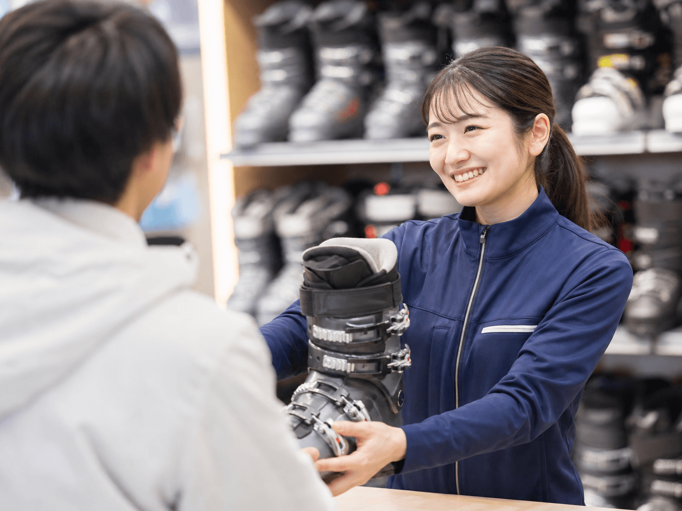 用具を貸し出すスキーレンタルスタッフ - Ski Rental Staff Handing Over Equipment
