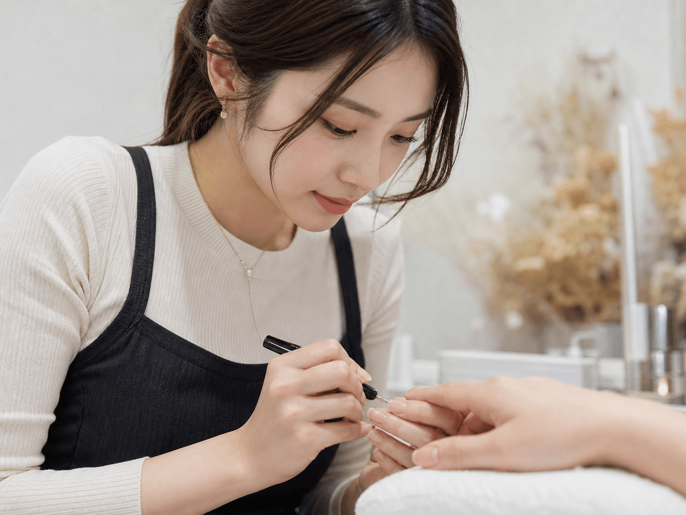 ネイルサロンで施術をするネイリスト - Nail technician applying gel polish at a nail salon