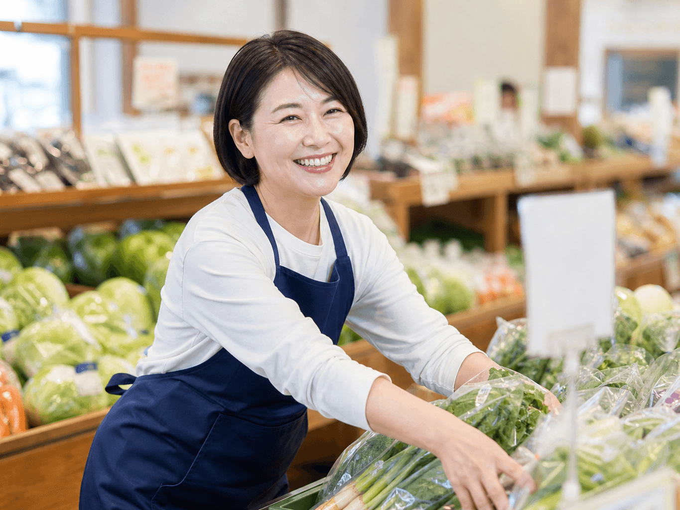 直売所で野菜を並べるスタッフ - Staff Arranging Vegetables at a Farm Stand