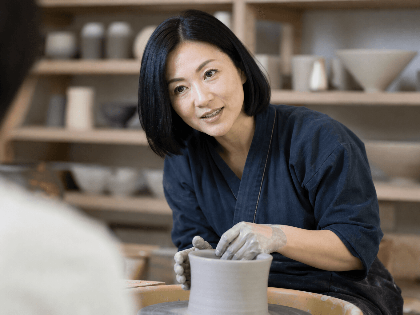 作陶を指導する陶芸家 - Ceramic Artist Teaching Pottery on a Wheel