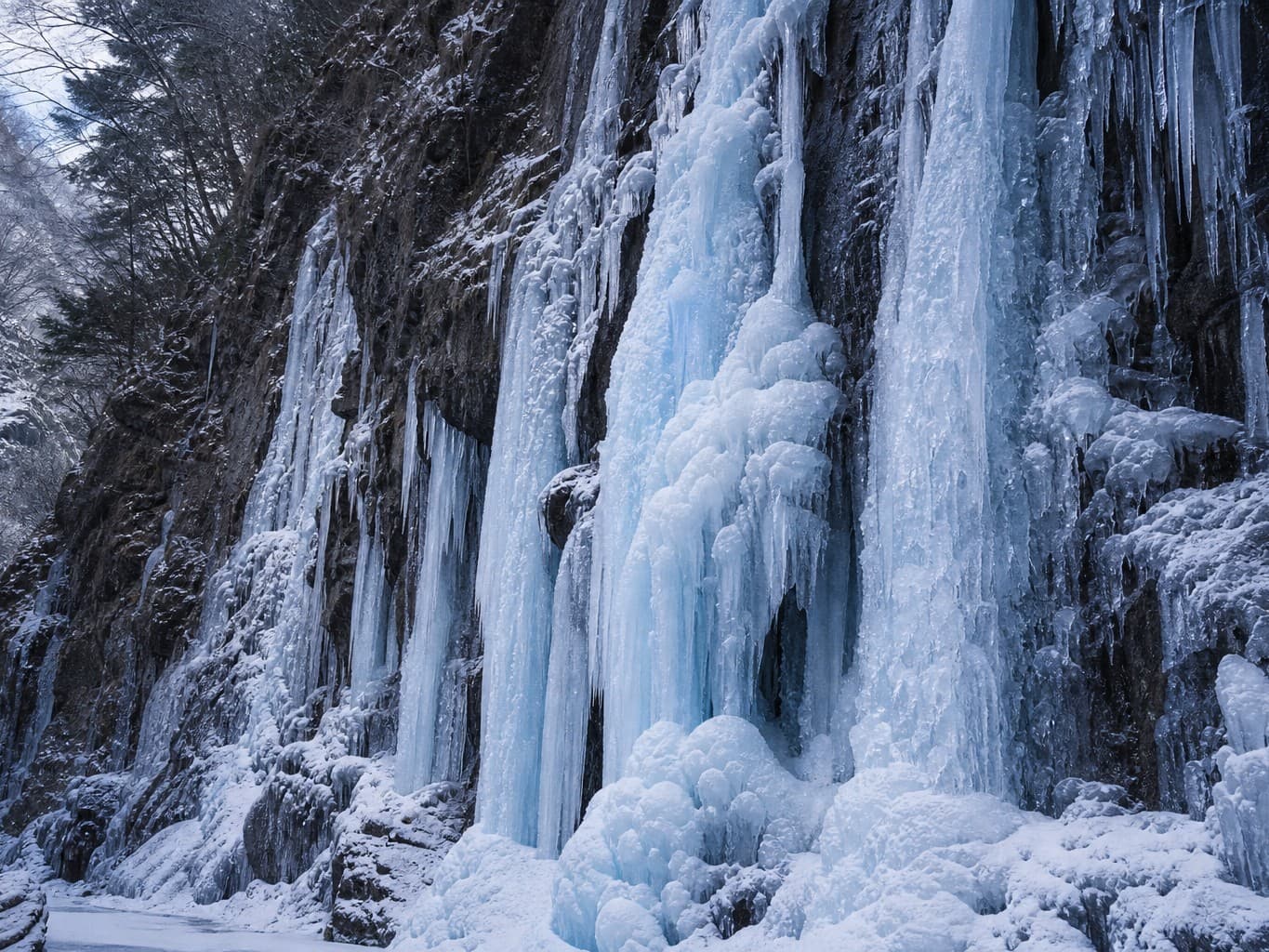 渓谷にそびえる凍った滝 - Frozen waterfall of blue-white ice on a canyon wall
