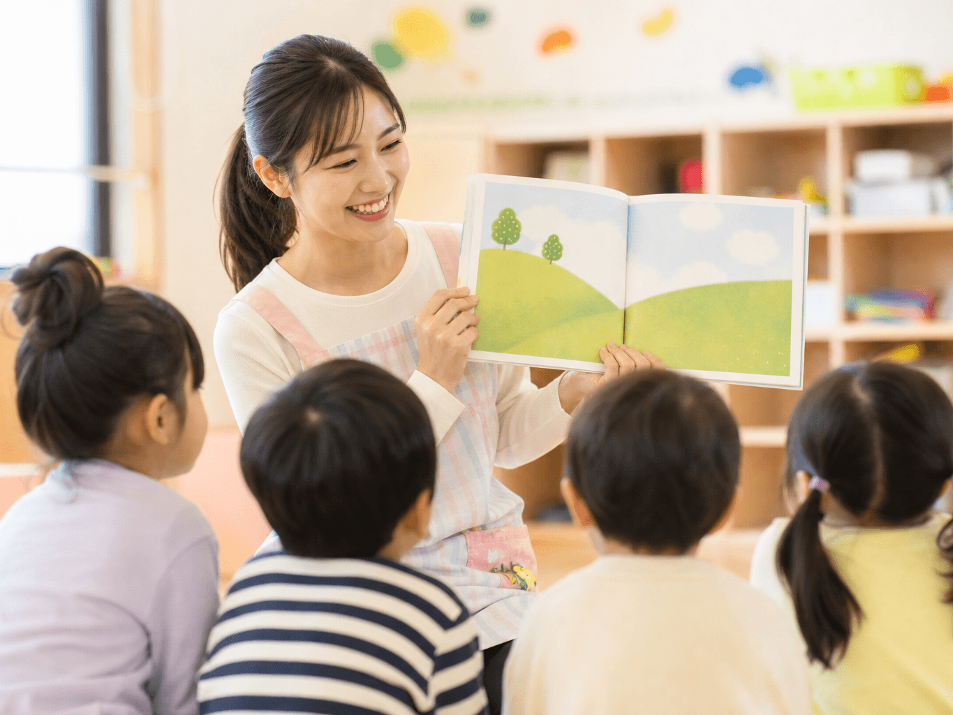 絵本を読み聞かせる保育士 - Nursery Teacher Reading a Picture Book to Children