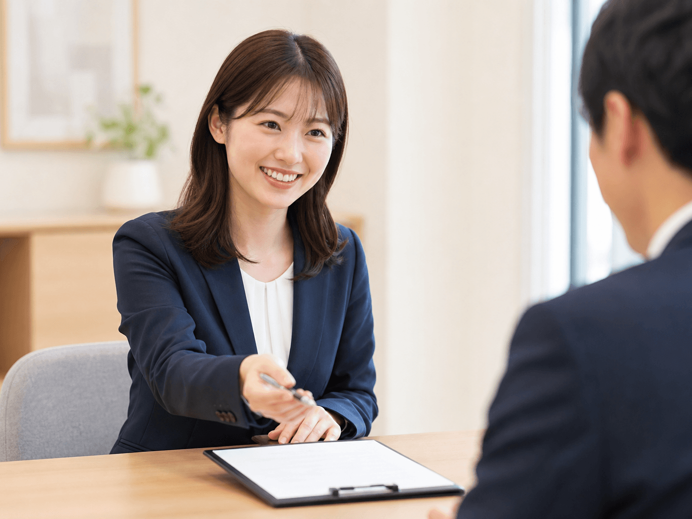 商談テーブルで契約書とペンを差し出す営業担当者 - Sales Representative Offering a Pen and Contract to a Client
