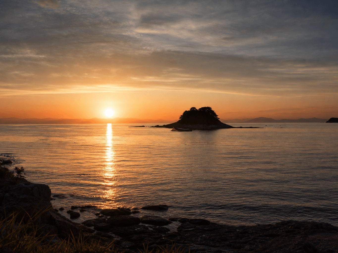 朝日に浮かぶ小島のシルエット - Silhouette of a small island at sunrise over the sea