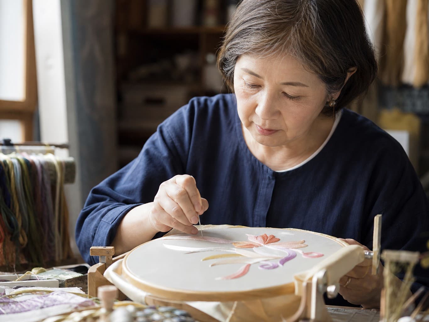 絹糸で布に刺繍をする刺繍師 - Embroiderer stitching silk thread onto fabric
