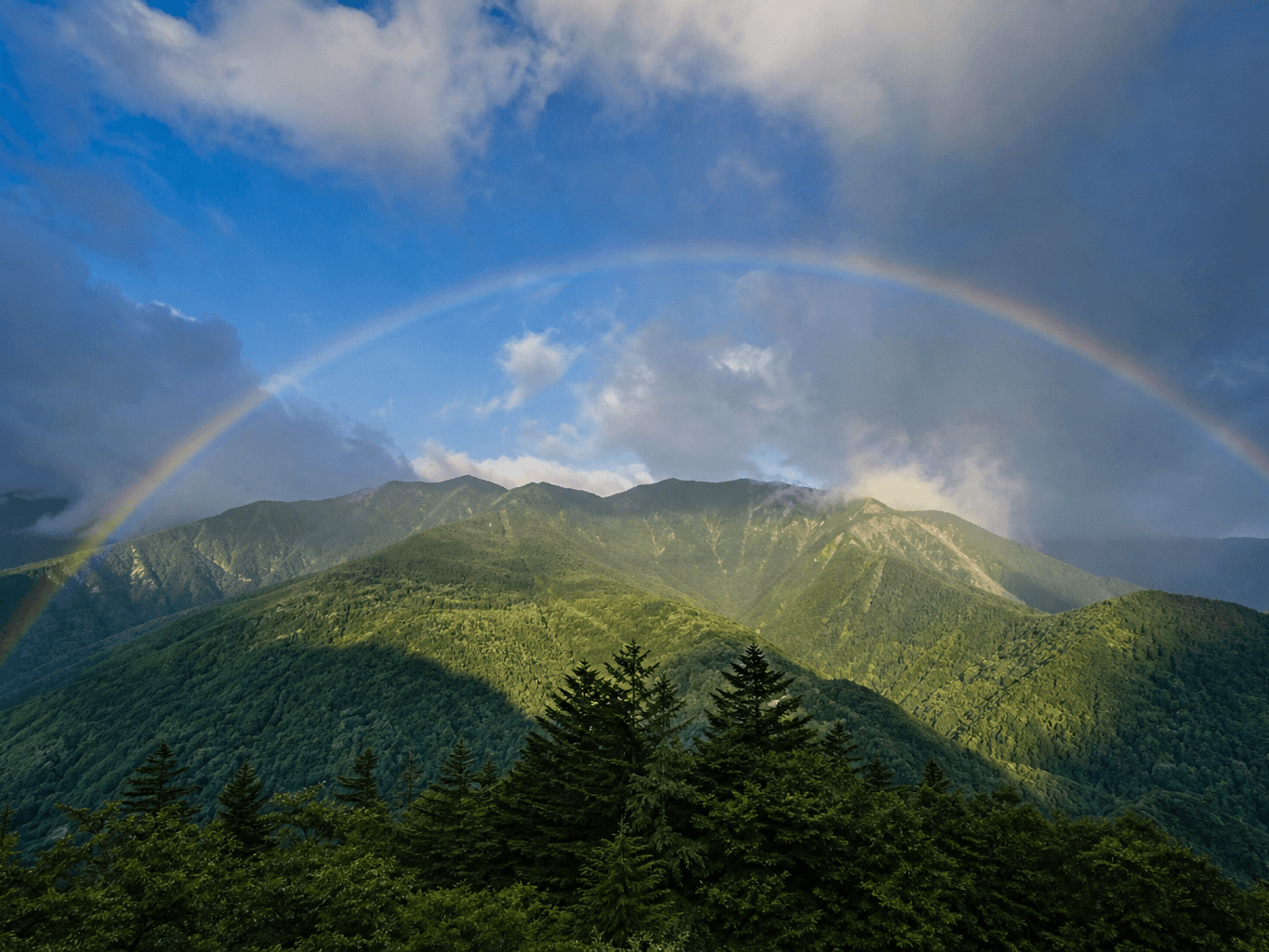 雨上がりの山々にかかる虹 - A large rainbow over mountains after rain
