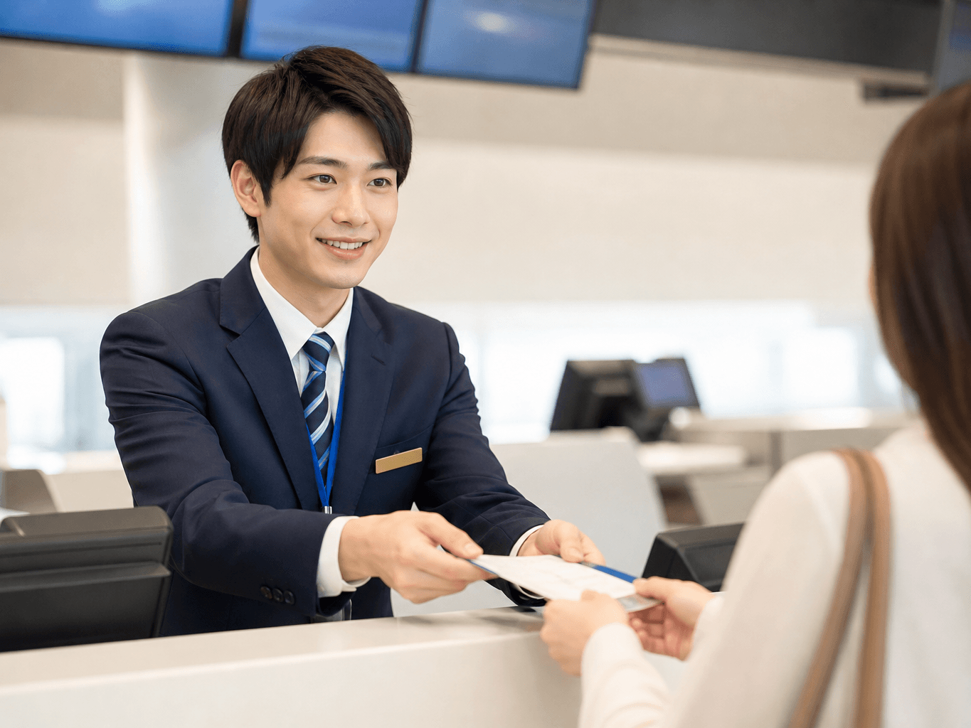空港のチェックインカウンターで搭乗券を渡しながら丁寧に案内するスタッフの様子 - Airport Check-in Staff Assisting a Passenger