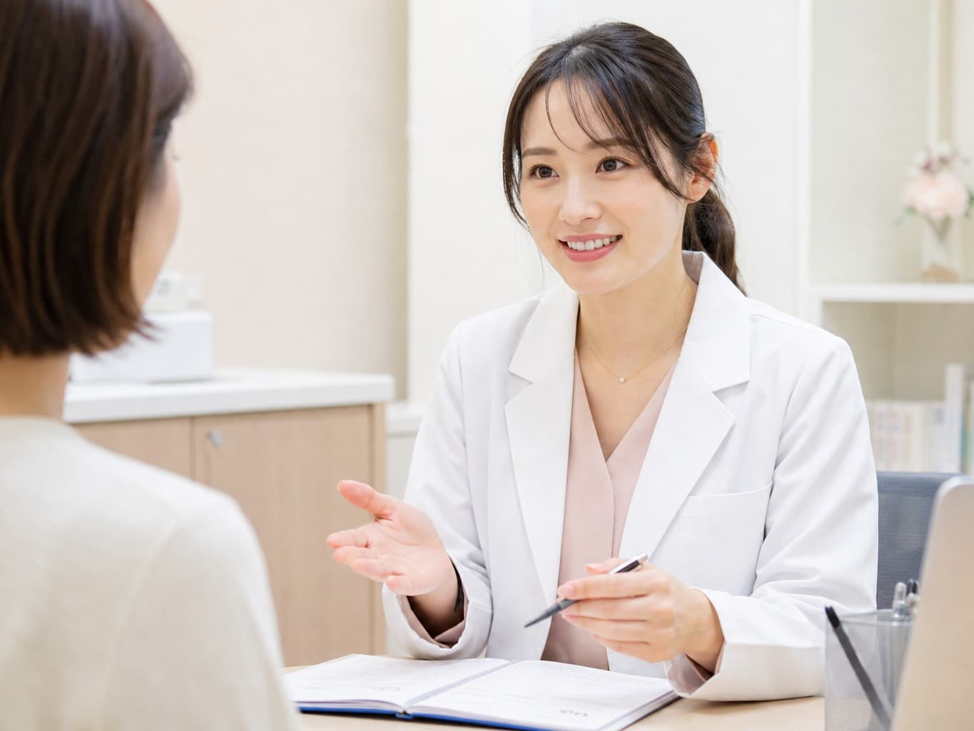 患者に説明をする産婦人科医 - Obstetrician explaining to a patient in an exam room