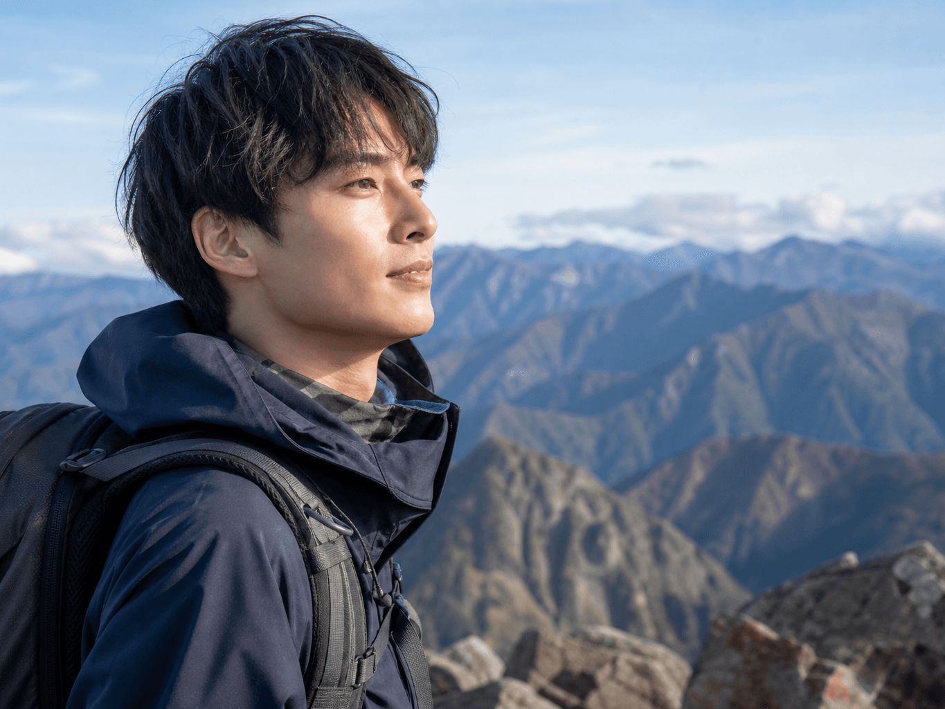 山頂から景色を眺める登山者 - Hiker admiring the mountain view from the summit