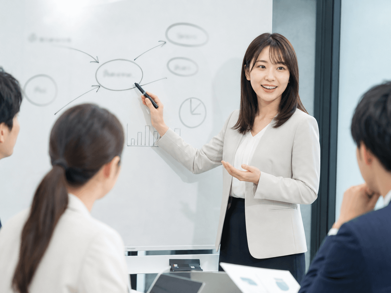 会議室のホワイトボードに図を描きながら熱心に説明する様子 - Explaining Ideas on a Whiteboard in a Meeting Room