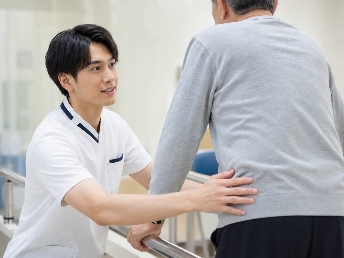 歩行訓練を支える理学療法士 - Physical therapist supporting a patient's walking practice