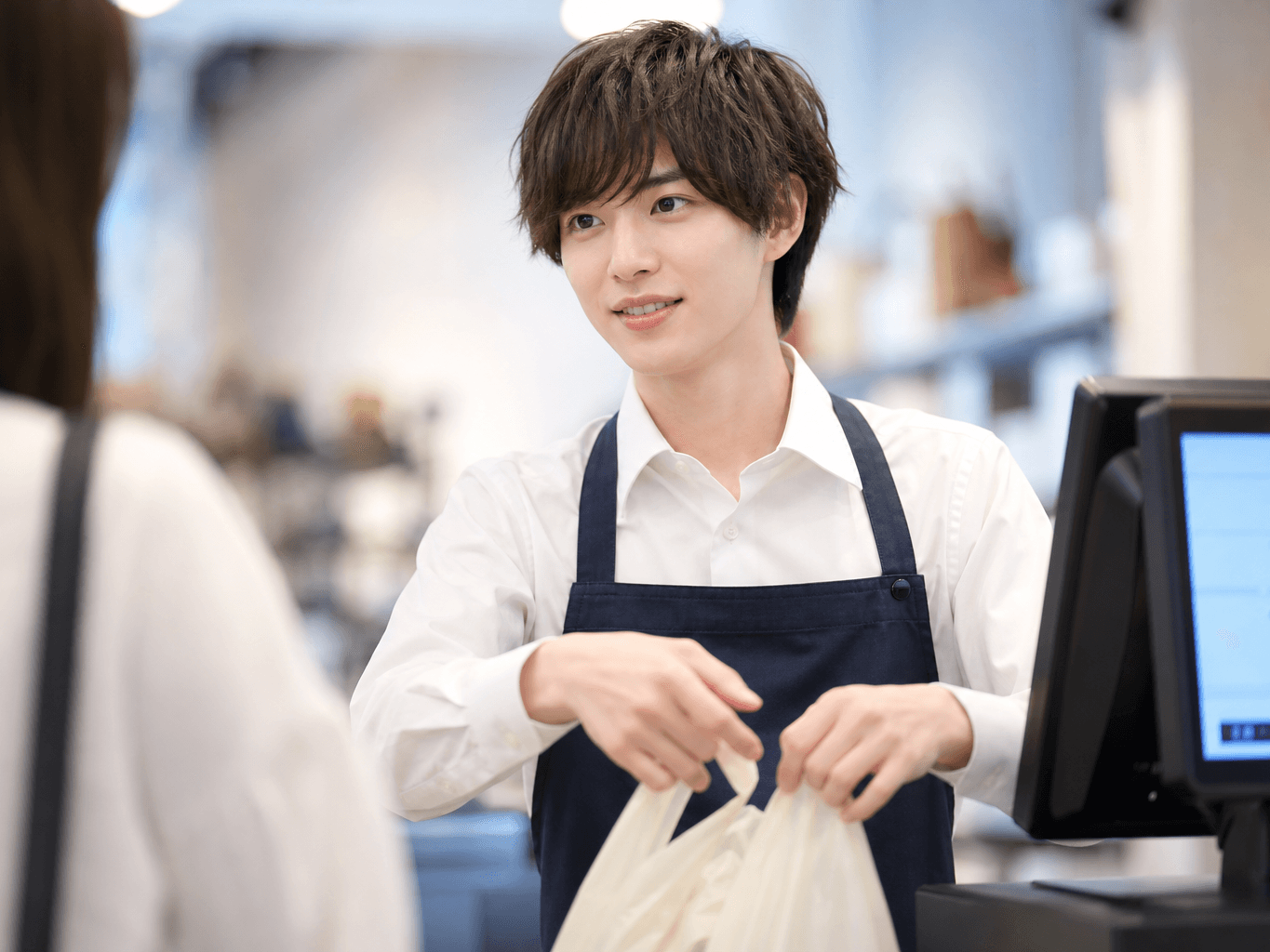 レジで会計対応をする店舗スタッフ - Retail Staff Handling Checkout at the Register