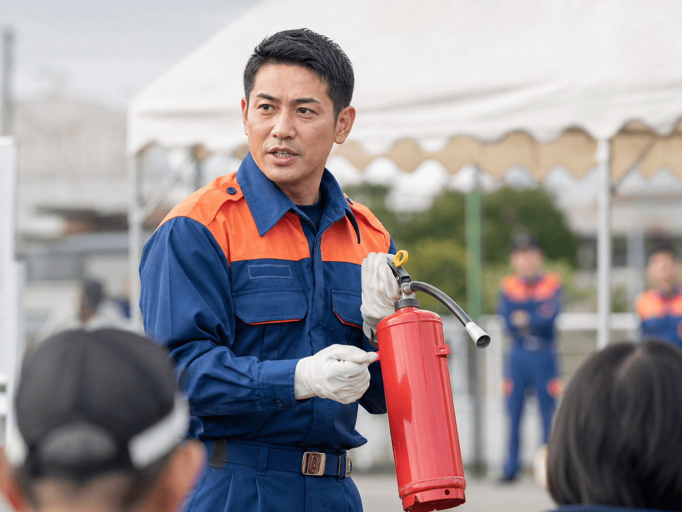 消火器の使い方を説明する消防団員 - Firefighter Demonstrating Fire Extinguisher Use
