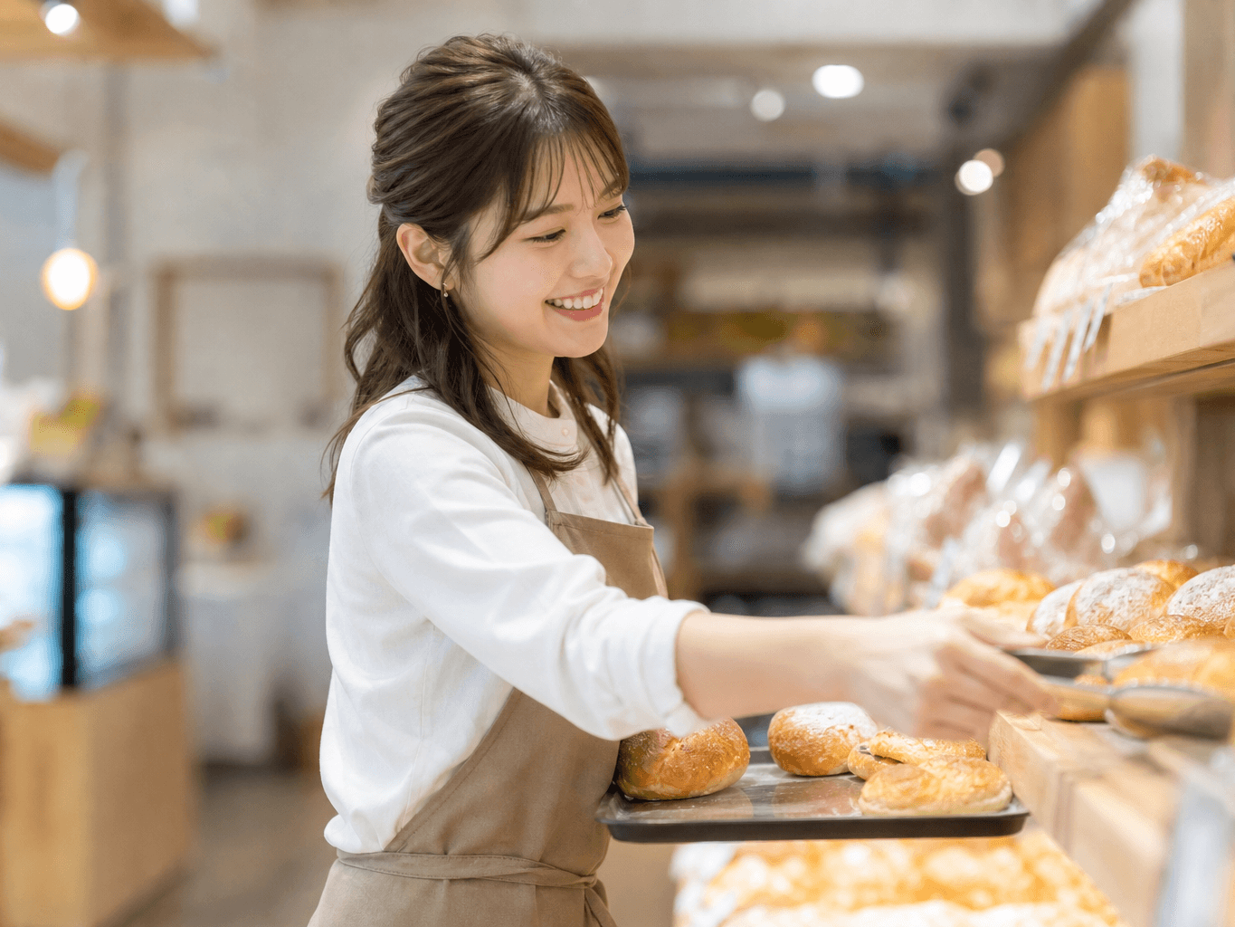 焼きたてパンを陳列するスタッフ - Bakery Staff Arranging Freshly Baked Bread