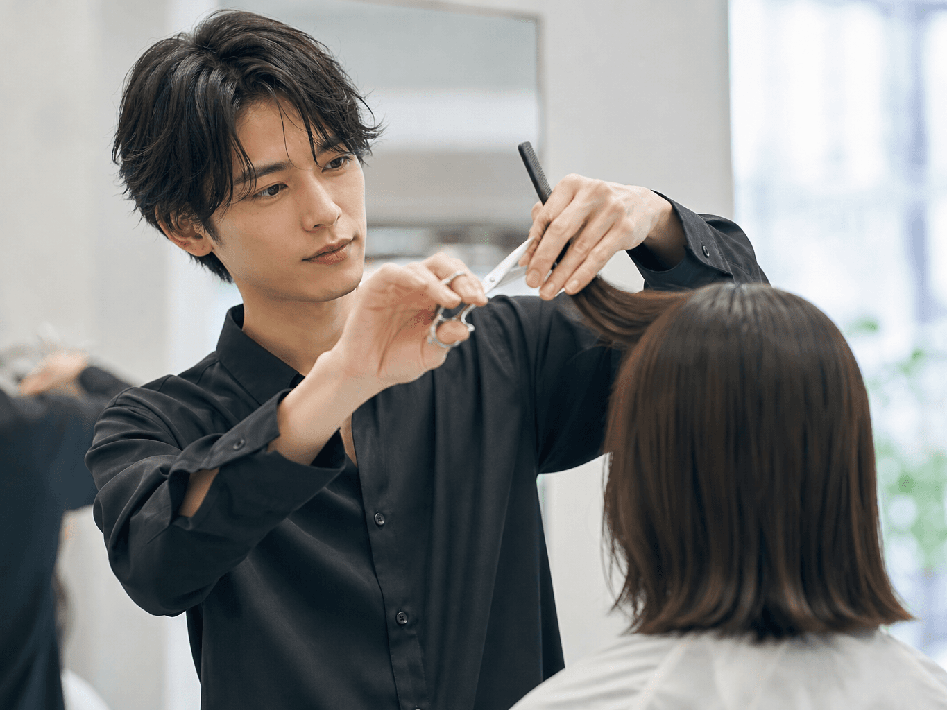 美容室でヘアカットをするスタイリスト - Hair stylist cutting a client's hair at a salon